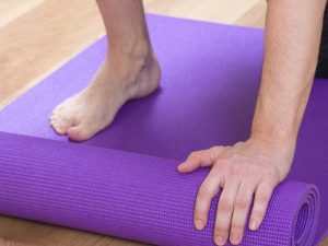 Close up of hands and feet on a yoga mat