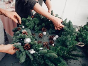 Hands decorating a Christmas Wreath