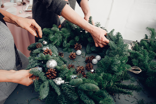 Hands decorating a Christmas Wreath
