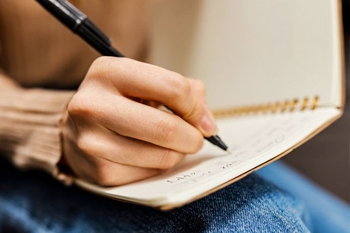 Close up of someone making handwritten notes in a book